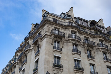 Fototapeta na wymiar Looking up at vintage Parisian apartment building with iron balconies