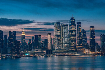 Fototapeta premium Manhattan skyline during early morning, dark buildings with vivid sky and clouds