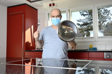 Mann mit Maske schützt sich in der Küche
