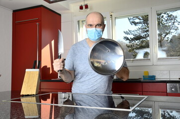 Mann mit Maske schützt sich in der Küche