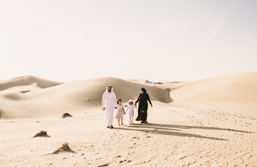 Happy family spending a wonderful day in the desert making a picnic. People from the emirates with...