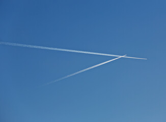 Two crossing flight lines in the blue sky