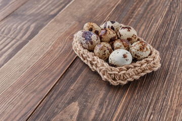 Group of quail eggs are put on clear tray on wooden table.