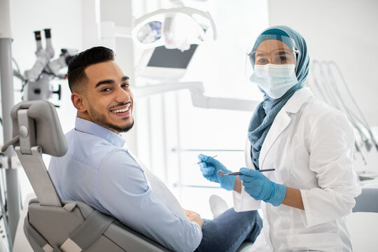 Portrait Of Happy Islamic Stomatologist Lady Having Check Up With Male Patient