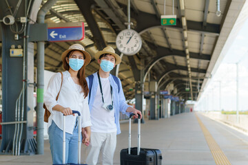 Asian travelers couple waiting train at the train station in Bangkok, Thailand, Travel and transportation concept