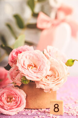 A bouquet of delicate pink roses. 8 march festive card with pink flowers on a light background, vertical photo with copy space for text
