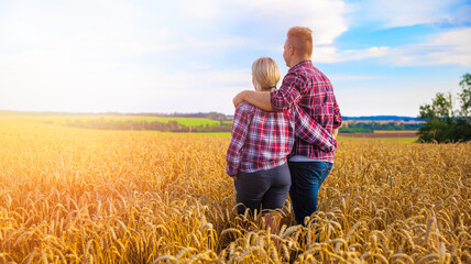 Couple farmers standing in wheat field together
