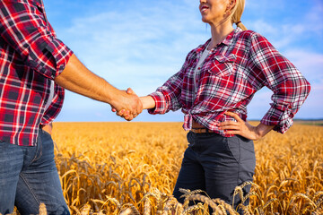 Farmer man and woman closing deal and shaking hands in a field