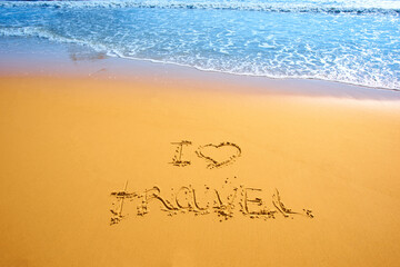 handwritten words I love travel on sand of tropical beach