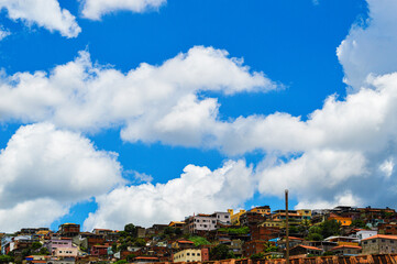 Fototapeta premium Beautiful landscape with blue sky many clouds and houses at the top of the hill. Sky Blue Clouds Houses on the hill.