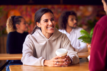 Couple On Date Meeting And Talking At Table In Coffee Shop