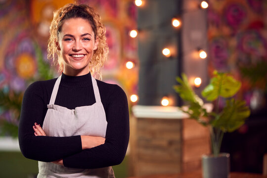 Portrait Of Smiling Female Server Working Night Shift In Bar Restaurant Or Club