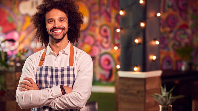 Portrait Of Smiling Male Server Working Night Shift In Bar Restaurant Or Club
