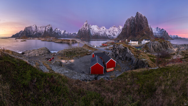 Fishing village near snowy mountains at sundown