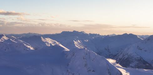 Aerial Panoramic View of Canadian Mountain covered in snow. Winter Sunset Sky Art Render. Located...
