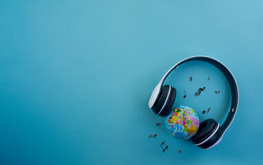headphones with a globe model and musical notes on a blue background