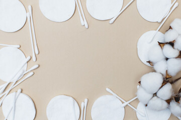 fluffy cotton flower cotton pads and cotton swabs on beige background with copy space. hygienic disposable product