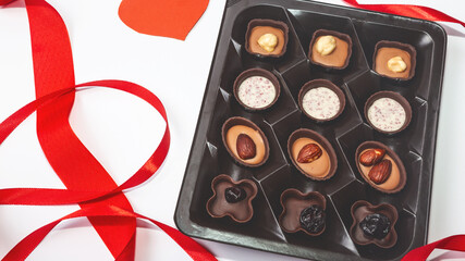 Delicious chocolate candies in gift box on a white background. Greeting card for Mother's Day, 8 March, Birthday, Valentines Day copy space flat lay