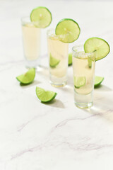 Three traditional tequila shots with lime and salt. Mexican tradition.