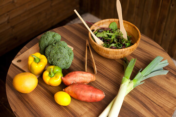 Vegetables and eco wooden bamboo bowl on the kitchen table for cooking homemade healthy dinner or lunch. Still life with sweet potato, broccoli, lettuce and other fruit and vegetables