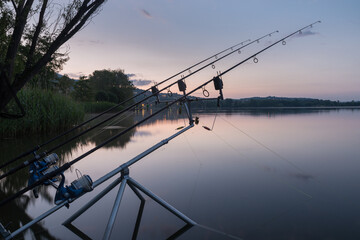 Fishing adventures, carp fishing at sunrise. Tranquility and nature at the lake. Fishing poles and...