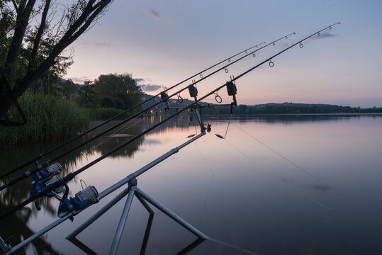 Fishing adventures, carp fishing at sunrise. Tranquility and nature at the lake. Fishing poles and reels, modern and technological equipment for sport fishing