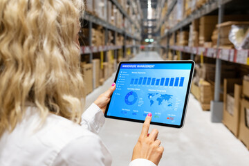 Woman working in warehouse and using digital tablet