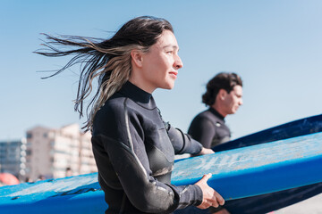 two latin surfers walking into the ocean to surf the waves, close up, in La Serena