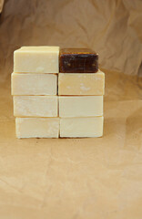 Light and dark bar of soap on a background of crumpled paper. The bars of soap were placed on top of each other. 