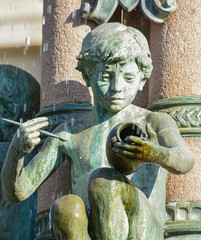Escultura de un niño pintando con pincel una vasija en la fuente del ayuntamiento de Limoges, Francia