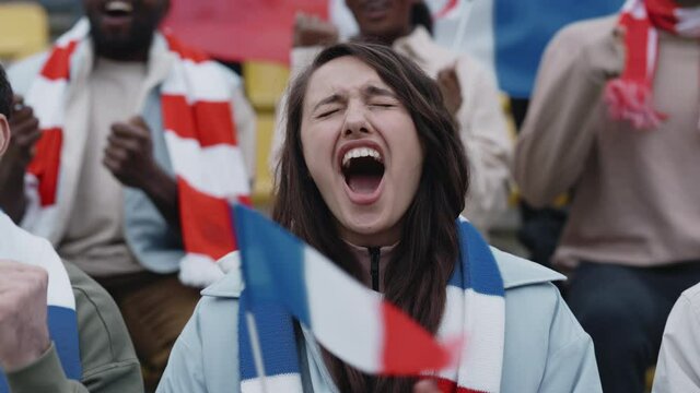 Woman cheering with french flag during football match