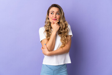 Young Brazilian woman isolated on purple background thinking an idea while looking up