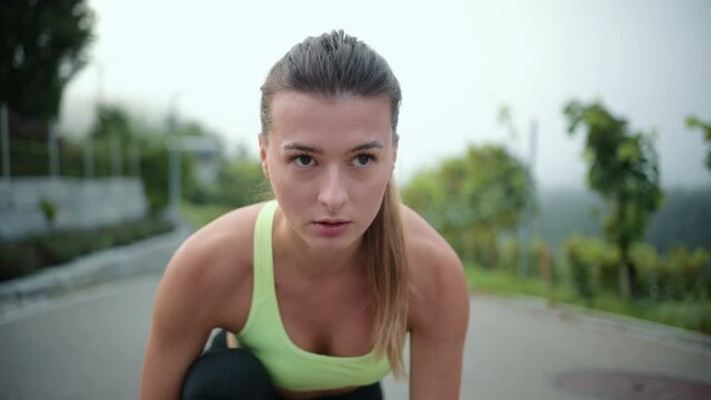 Young caucasian fit sport woman stretching her body warm up before workout outdoor. Beautiful female in sportswear exercises in the street for health and wellbeing.
