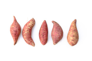 Five purple sweet potatoes are various shapes on a white background.