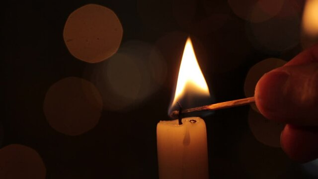 The candle light up over the bokeh window glass in the dark.