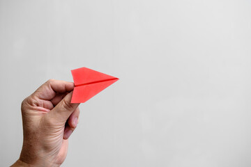 red paper airplane in the hands of a man