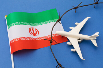 Toy plane, Iranian flag and barbed wire on colored background, Iran air border violation concept