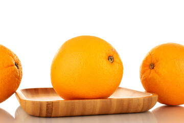 Three juicy oranges on a bamboo plate, macro, isolated on white.