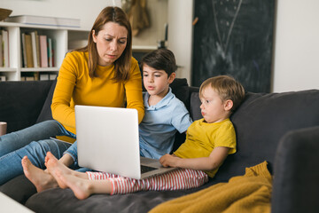 mother and kids using laptop computer at home