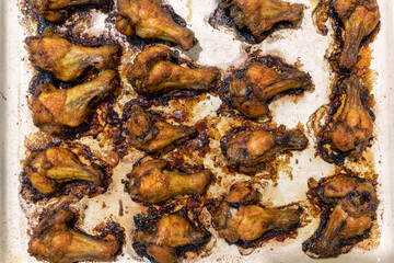 Fried chicken wings on a white baking sheet