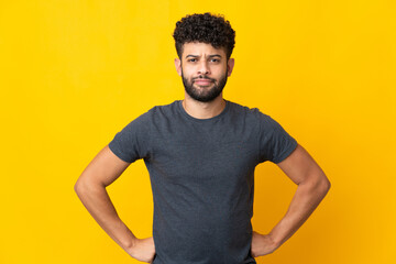 Young Moroccan man isolated on yellow background angry