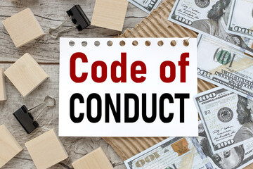 Code of Conduct. text on white paper on wooden table near wooden cubes