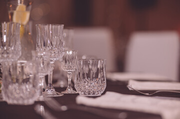 Empty crystal glasses on house dinner table. Restaurant, banquet setting with crystal glasses