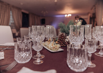 Empty crystal glasses on house dinner table. Restaurant, banquet setting with crystal glasses