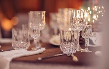 Empty crystal glasses on house dinner table. Restaurant, banquet setting with crystal glasses