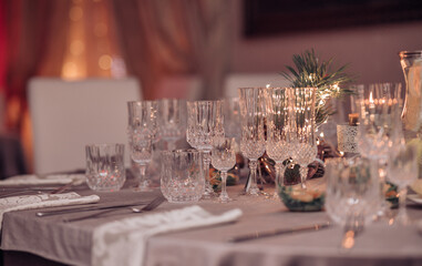 Empty crystal glasses on house dinner table. Restaurant, banquet setting with crystal glasses
