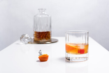 Vaso de vermut con hielo decorado con cerezas, rodajas de naranja y decantador sobre mesa blanca	 - obrazy, fototapety, plakaty
