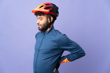 Young Moroccan cyclist man isolated on purple background suffering from backache for having made an effort