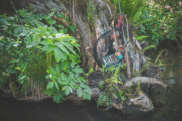 Fishing landing net and rod on the background of a forest stream. Fly fishing and tenkara.