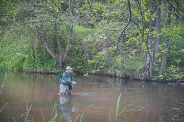 The fisherman catches with a spinning rod on the river.